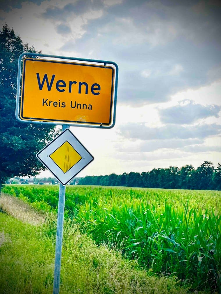 Ortsschild „Werne, Kreis Unna“ an einer Landstraße vor einem Kornfeld